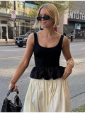 "Black peplum top and white skirt two-piece outfit styled on city streets"